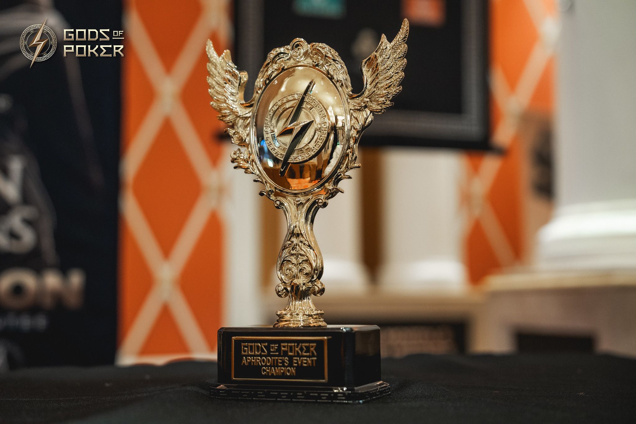 A detailed golden winged trophy with a flame design sits on a dark base.