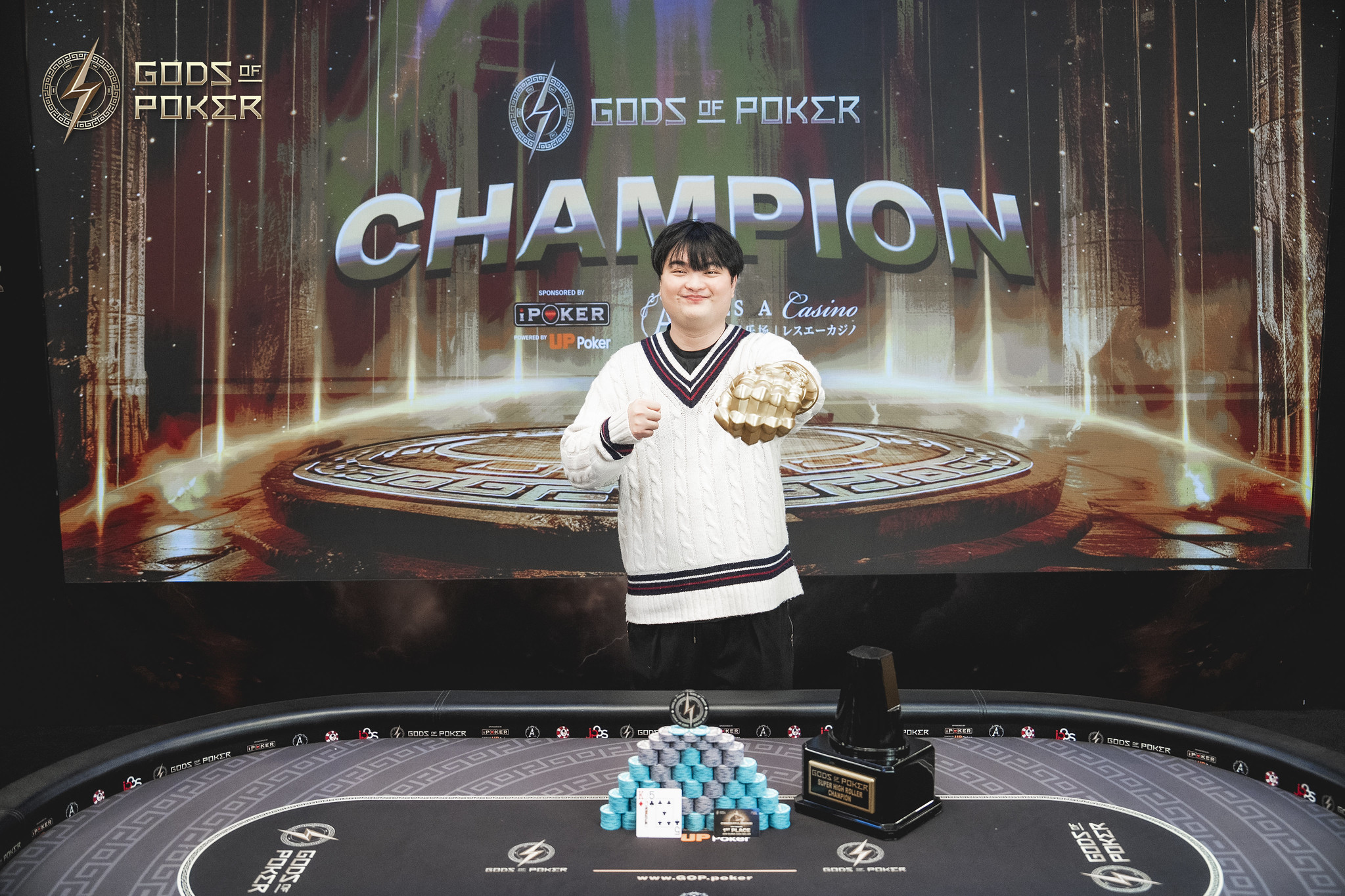 A poker champion stands proudly with a golden trophy in front of a 'CHAMPION' screen.
