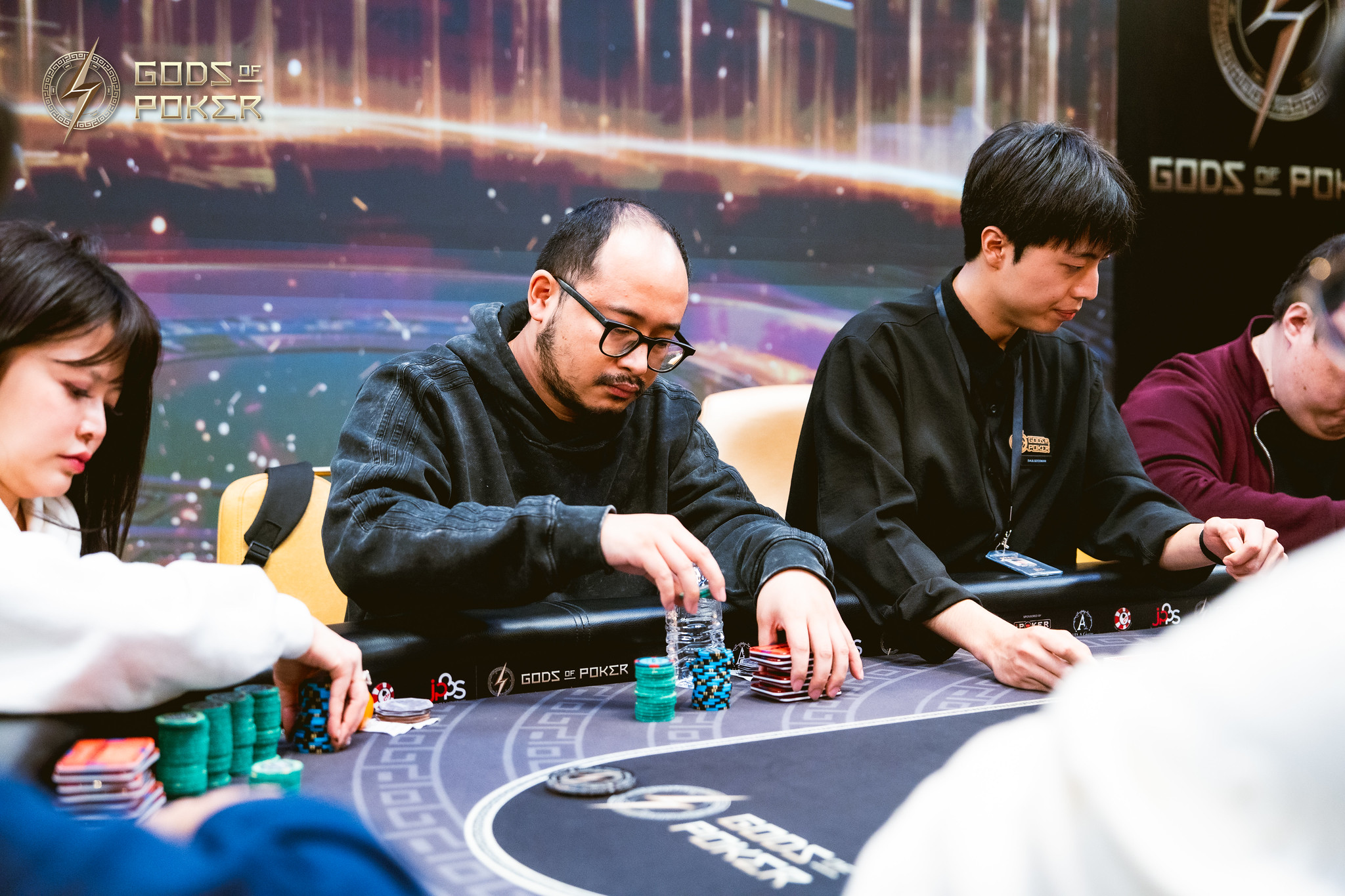 Man in glasses concentrates while playing poker at a table with chips.