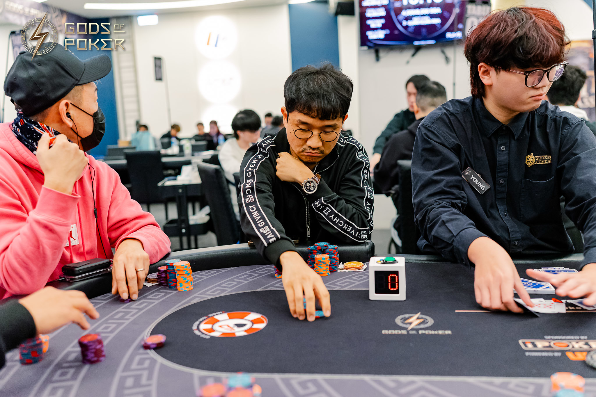 Three men are intensely focused on playing poker at a table with chips.