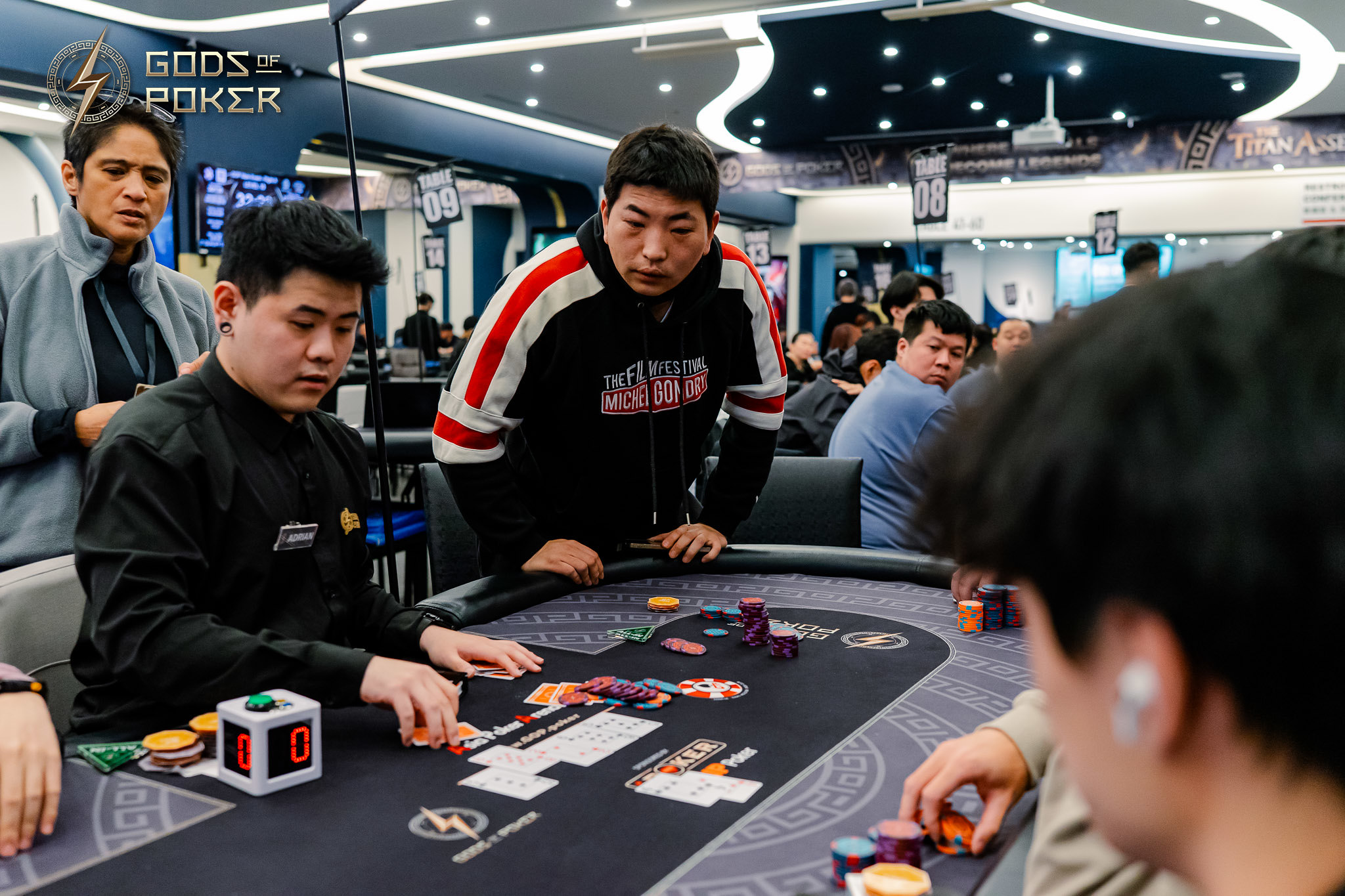 Two men intensely focused on a poker game with chips and cards on a table.