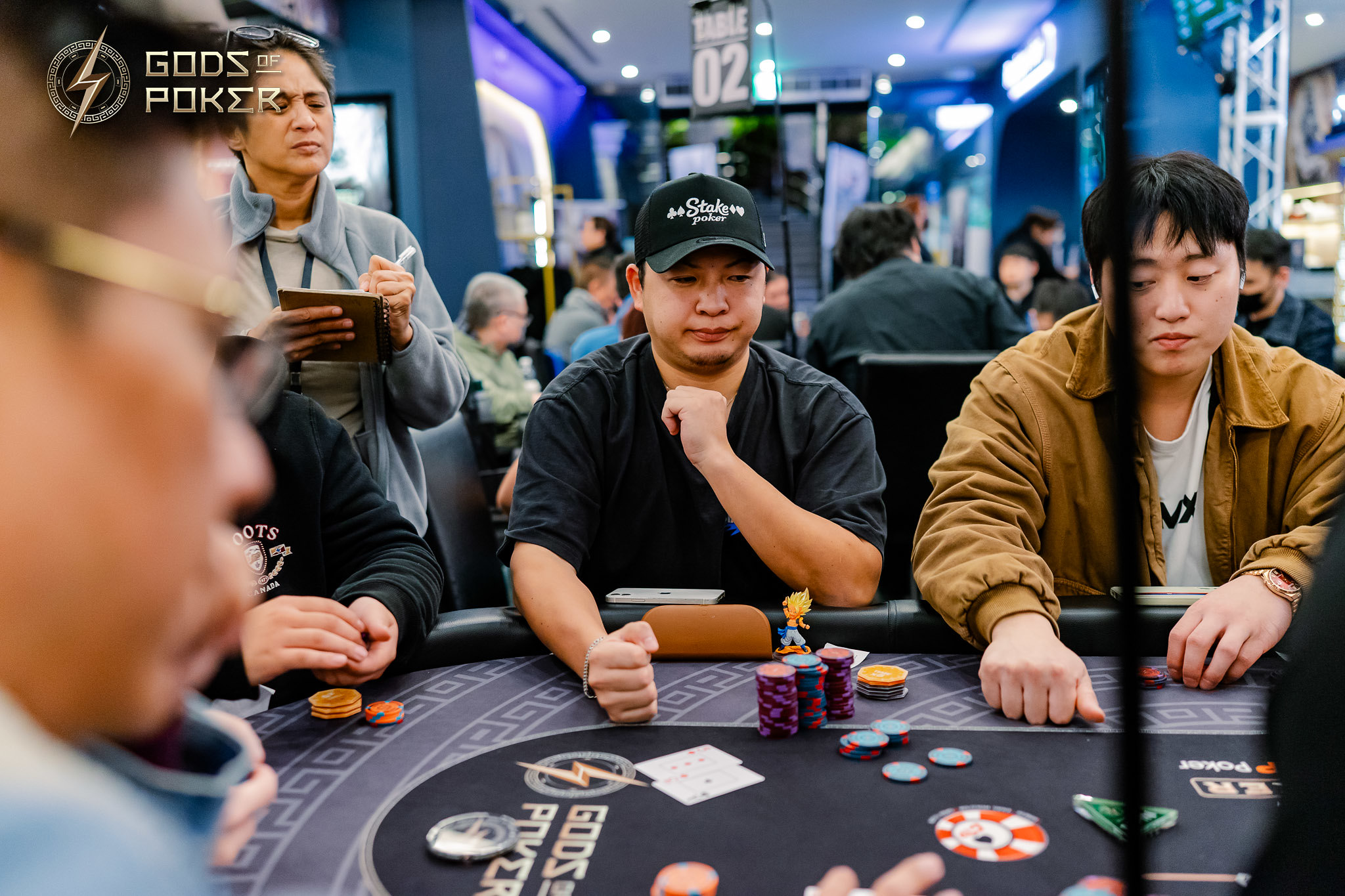 Three men intently playing poker at a casino table with chips and cards.