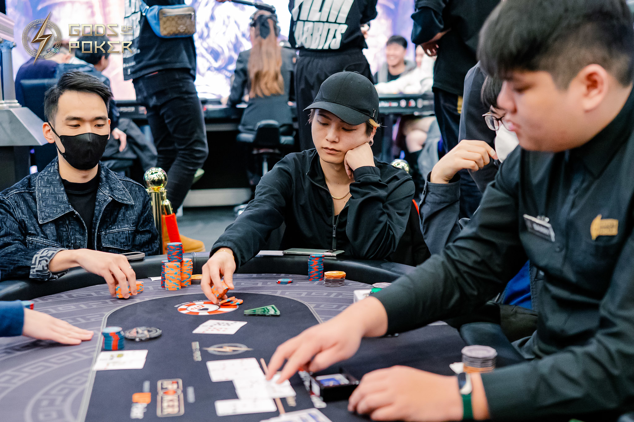 Three men intensely focused on playing poker at a brightly lit casino table with chips and cards.