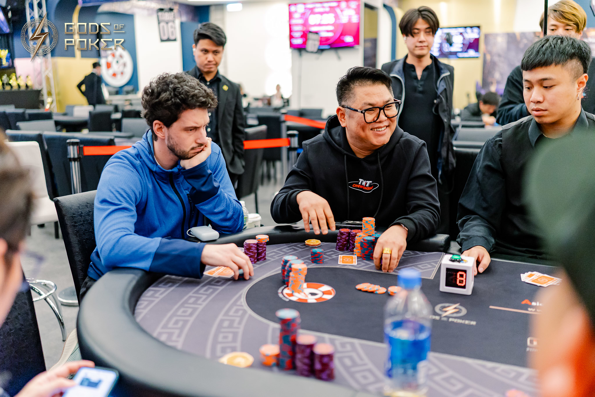 Two men playing poker at a casino table, surrounded by chips and cards.