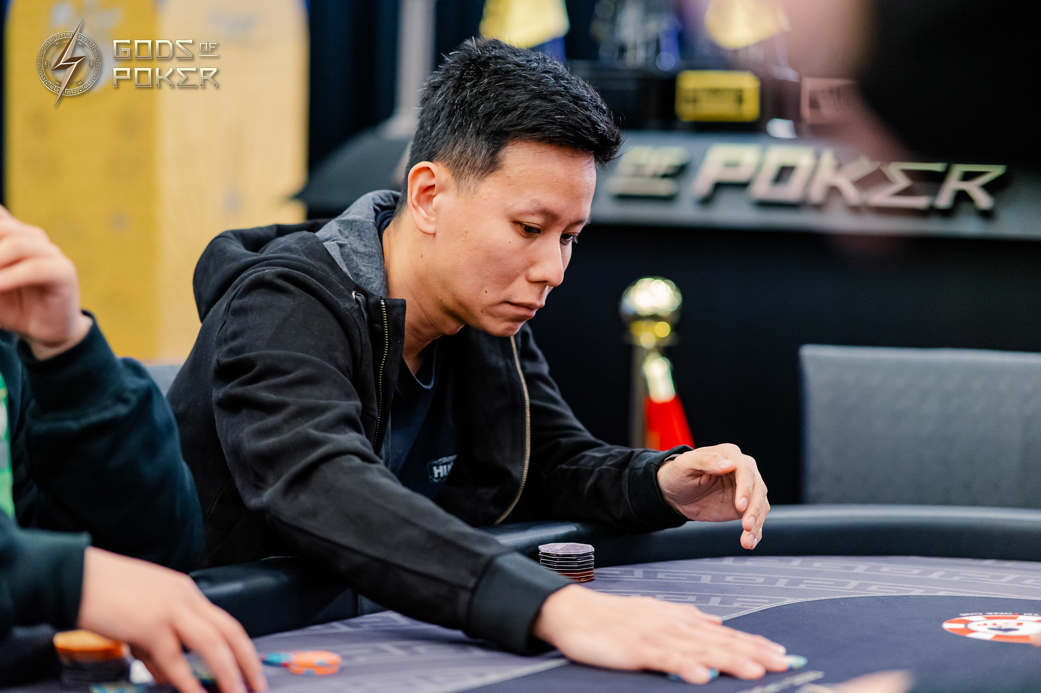 Man intensely focused on a poker game, his hands near chips on the table.