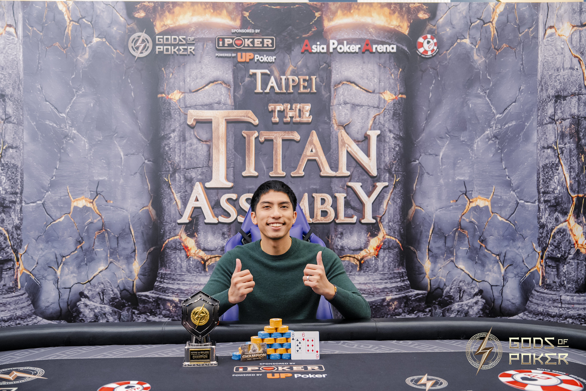 A man celebrates winning the Taipei The Titan Assembly poker tournament with a trophy and chips.