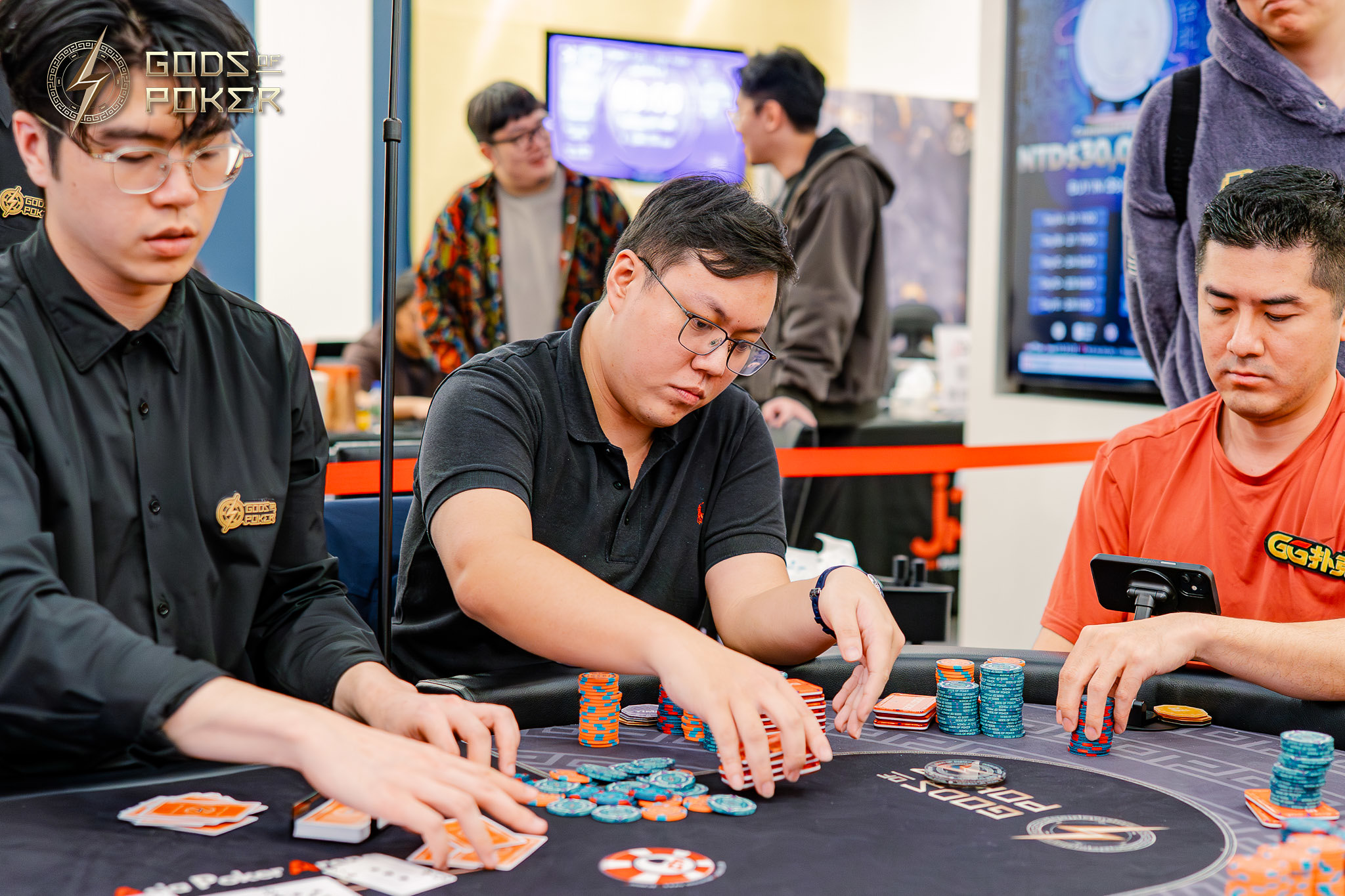 Three men intently playing poker at a table with chips and cards.