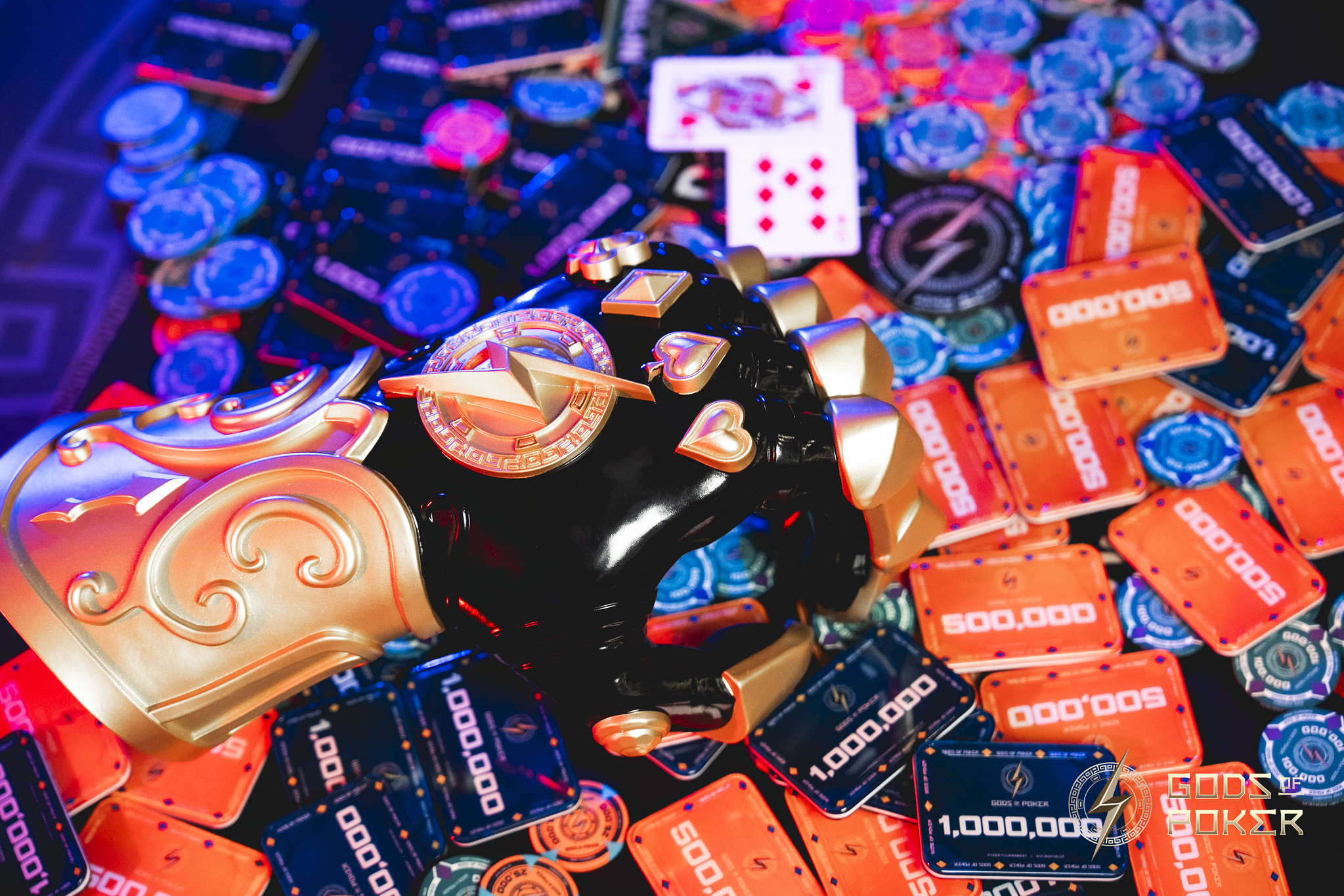 A scattered collection of colorful poker chips, dice, high-value chips, and a golden gauntlet.