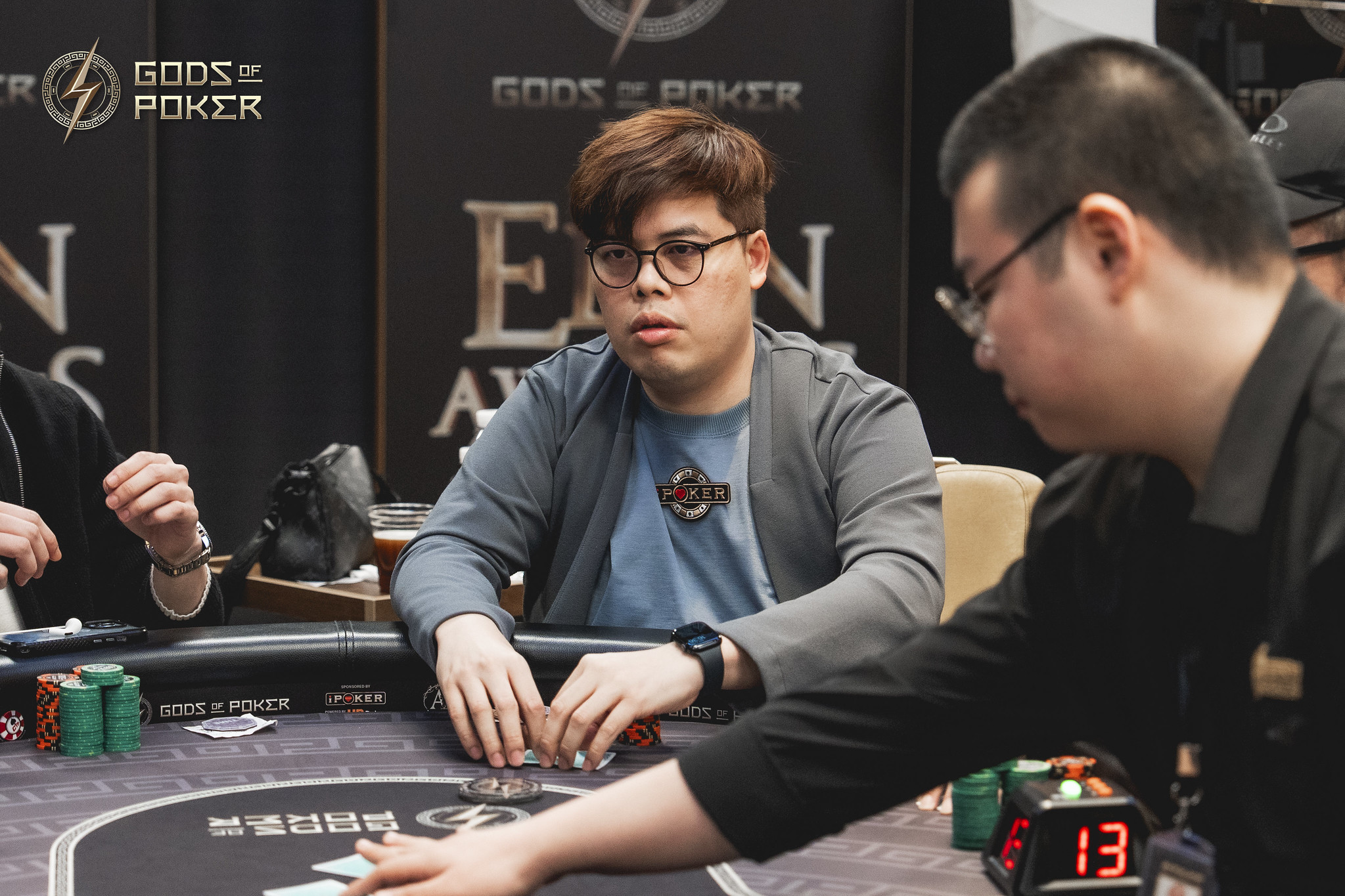 Two players engaged in a poker game at a table with chips.