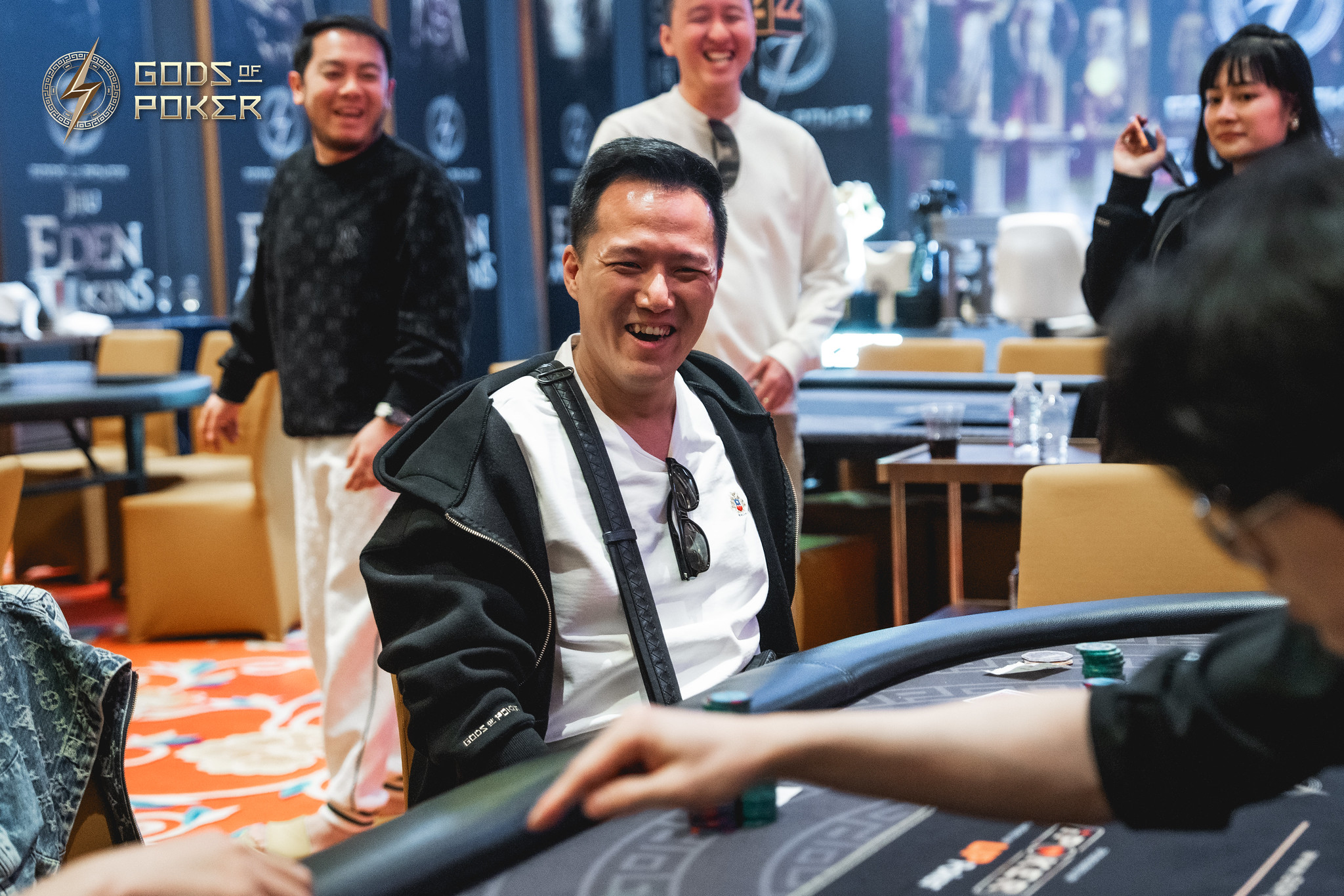 Smiling man sitting at a poker table during a