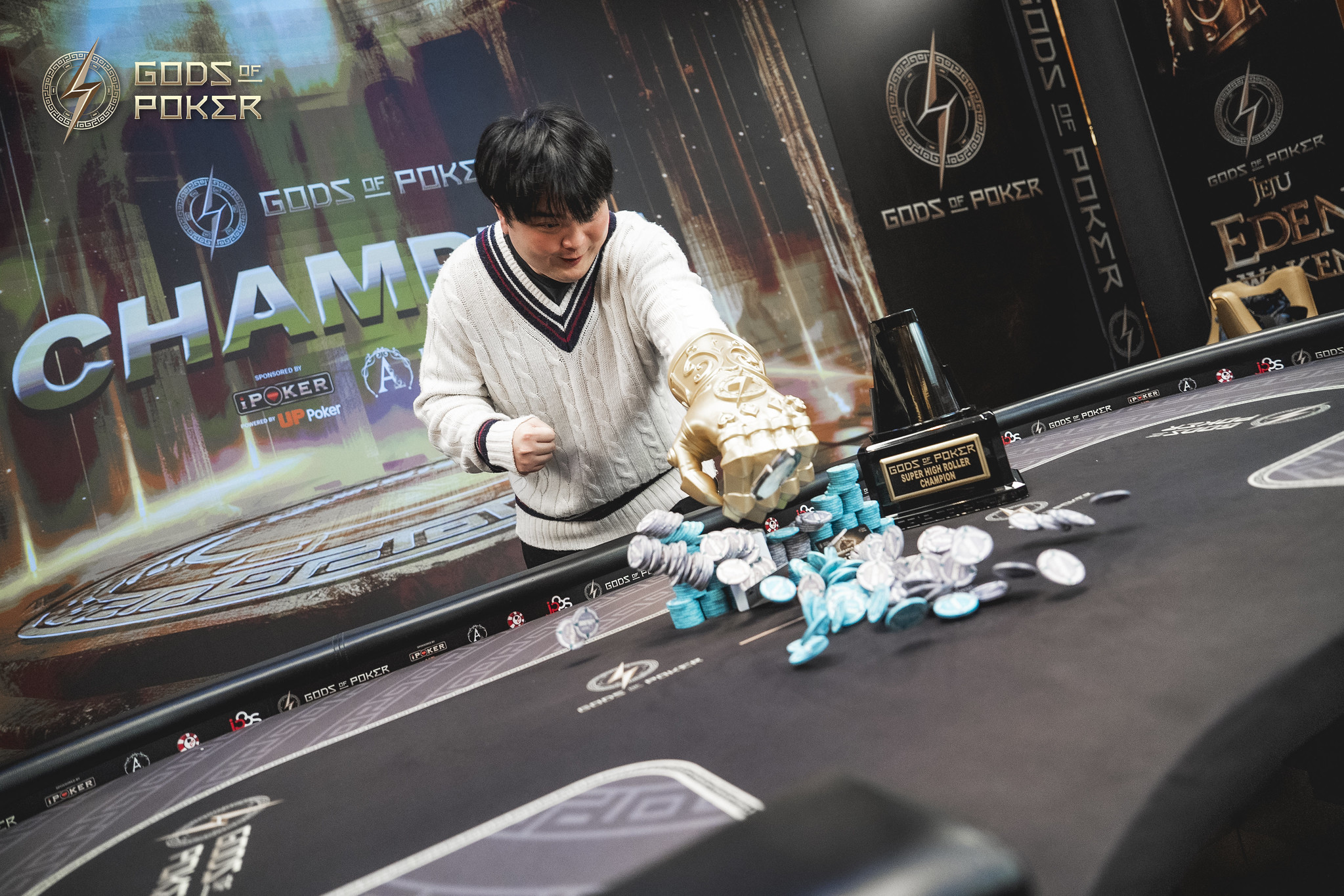A man pours poker chips from a golden trophy onto a poker table after winning.