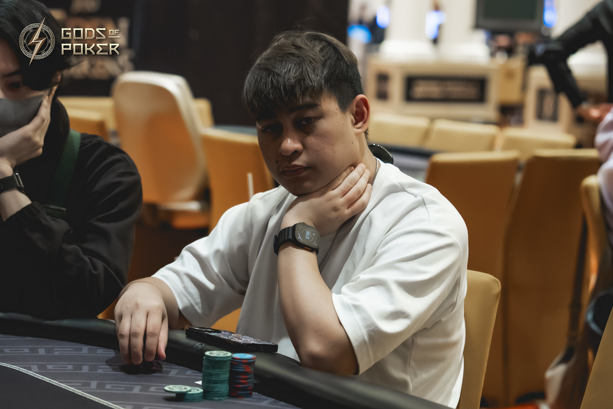Young man thoughtfully considering his next move at a poker table with chips.