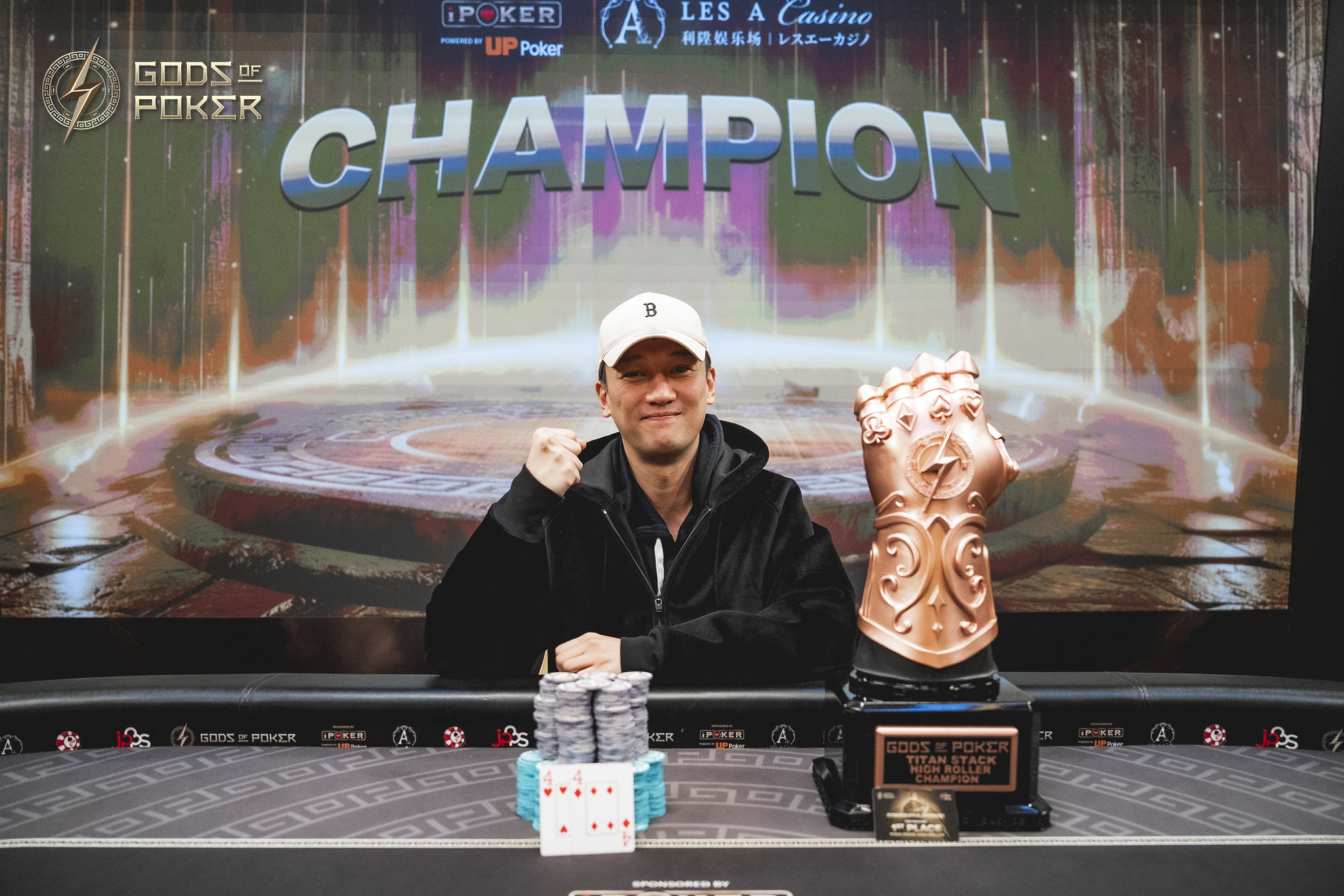 A poker champion celebrates victory, proudly displaying a unique gauntlet trophy and chips.