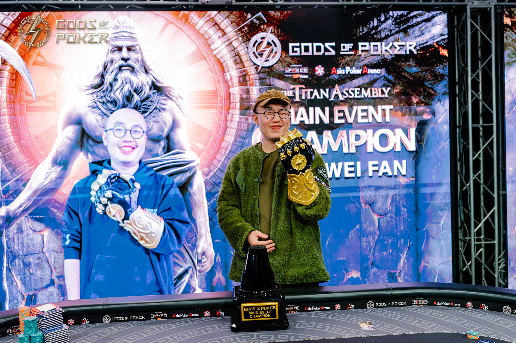 Wei Fan, the poker main event champion, holds his trophy and championship belt.