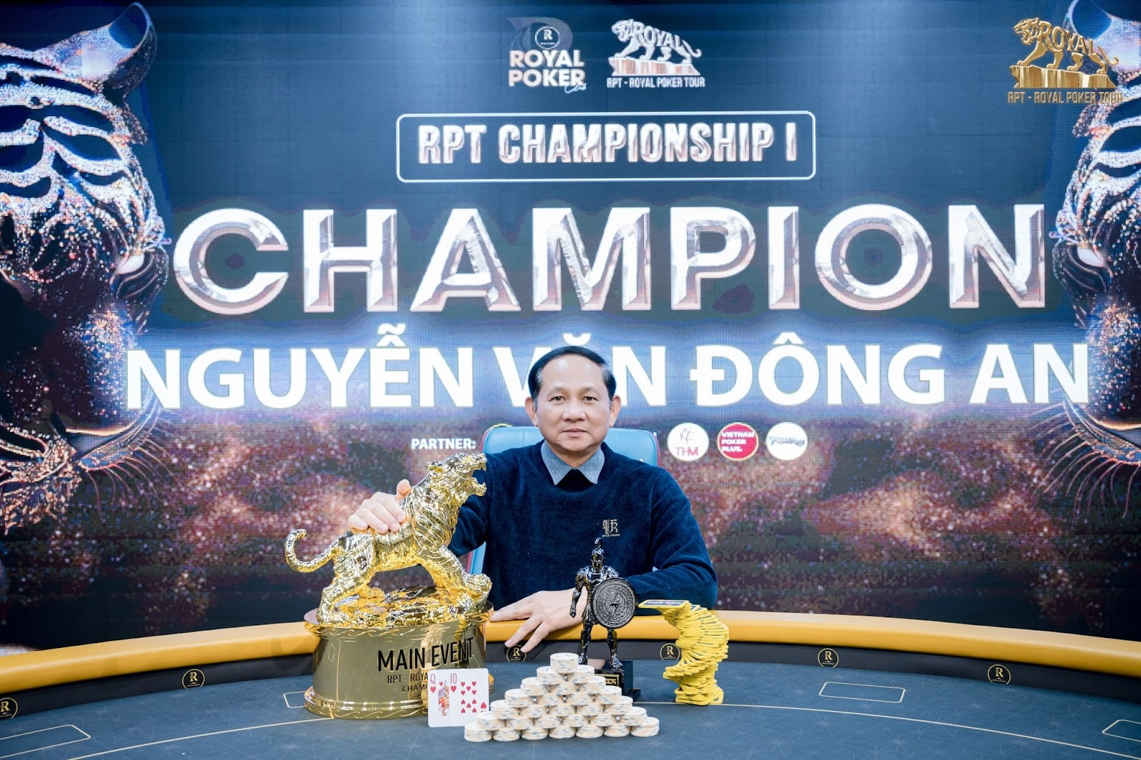 Poker champion Nguyen Van Dong An celebrates his RPT Championship victory with multiple trophies.
