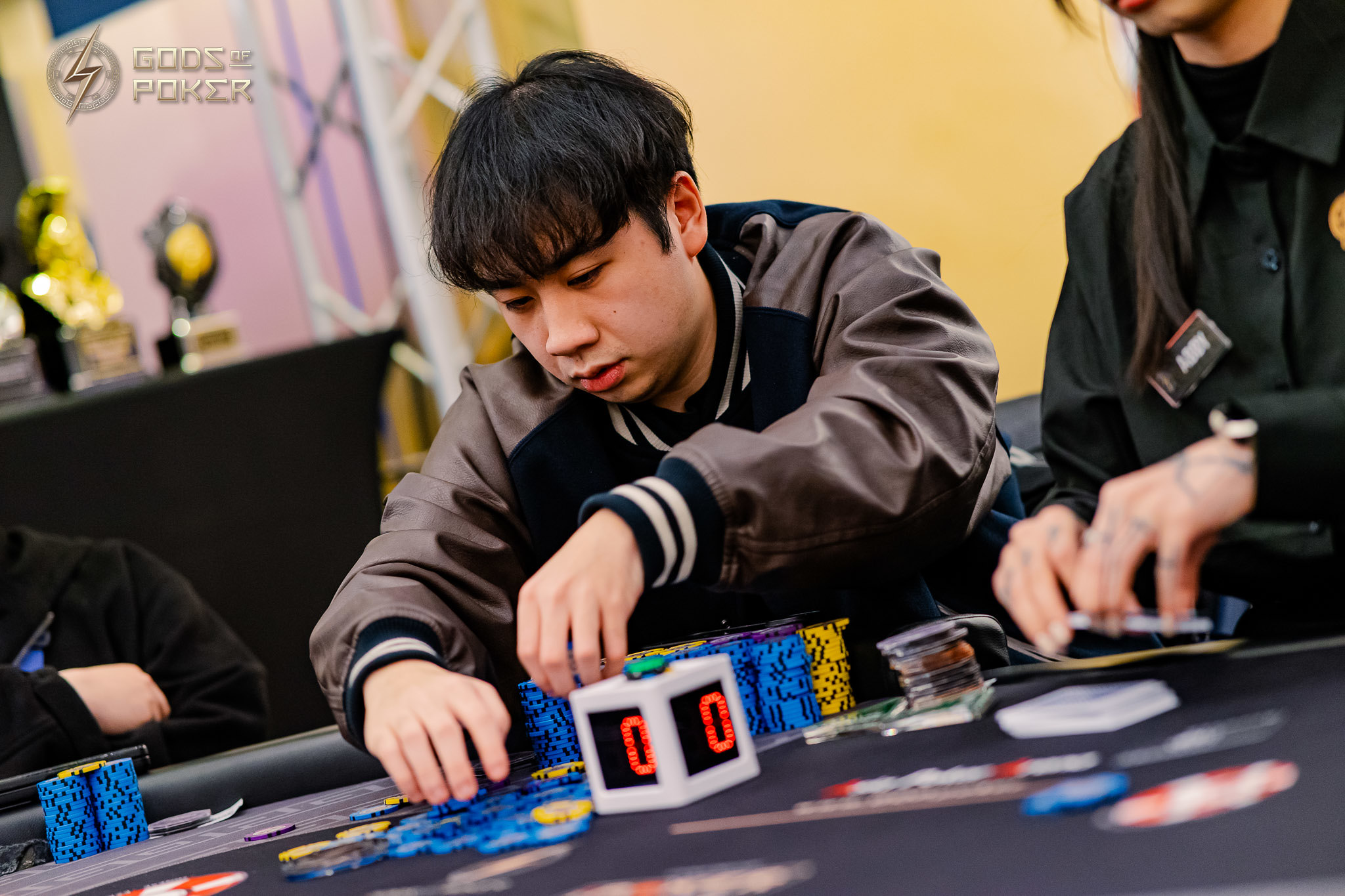 Young man focused on arranging poker chips at a casino table during a game.