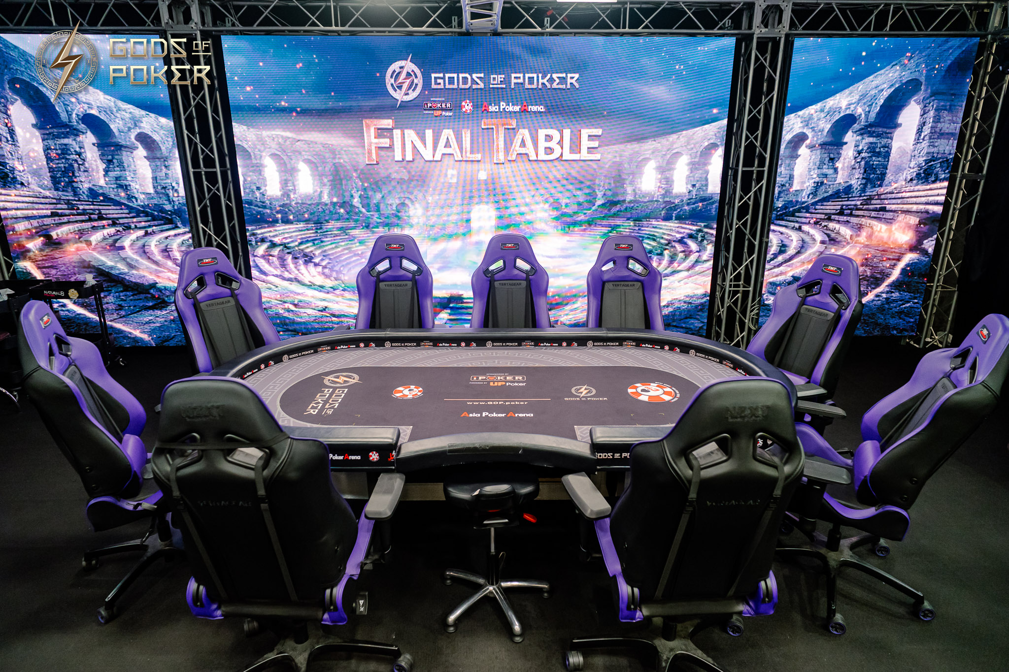 Poker table setup with gaming chairs and a large screen displaying 'Final Table'.