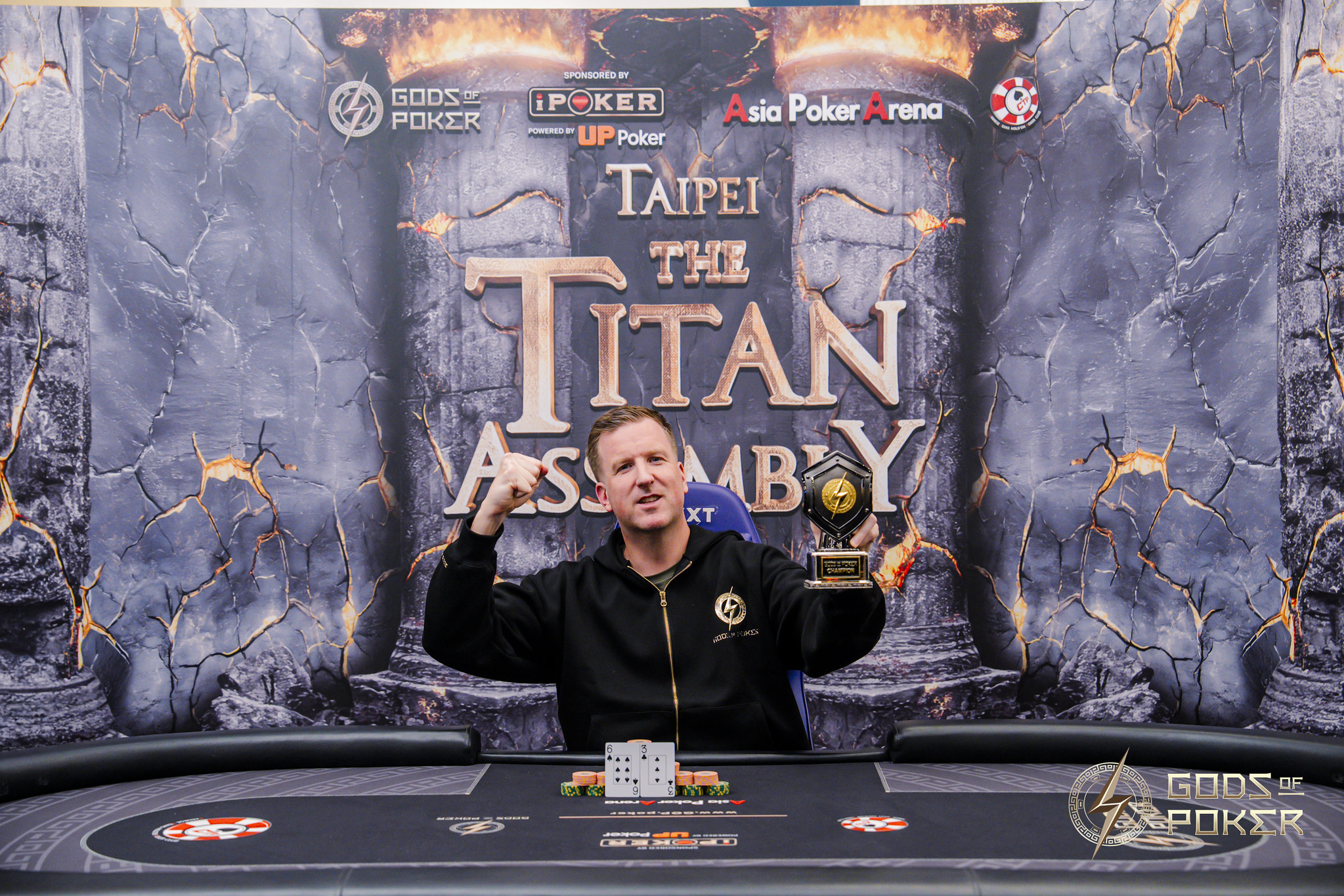 Excited poker player holding a trophy, celebrating victory at the Titan Assembly tournament.